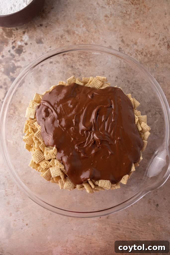 Pouring the melted chocolate peanut butter mixture over Chex cereal.
