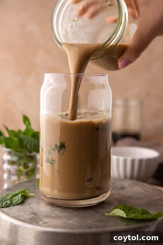 Hand pouring mojito iced coffee in a cup full of ice