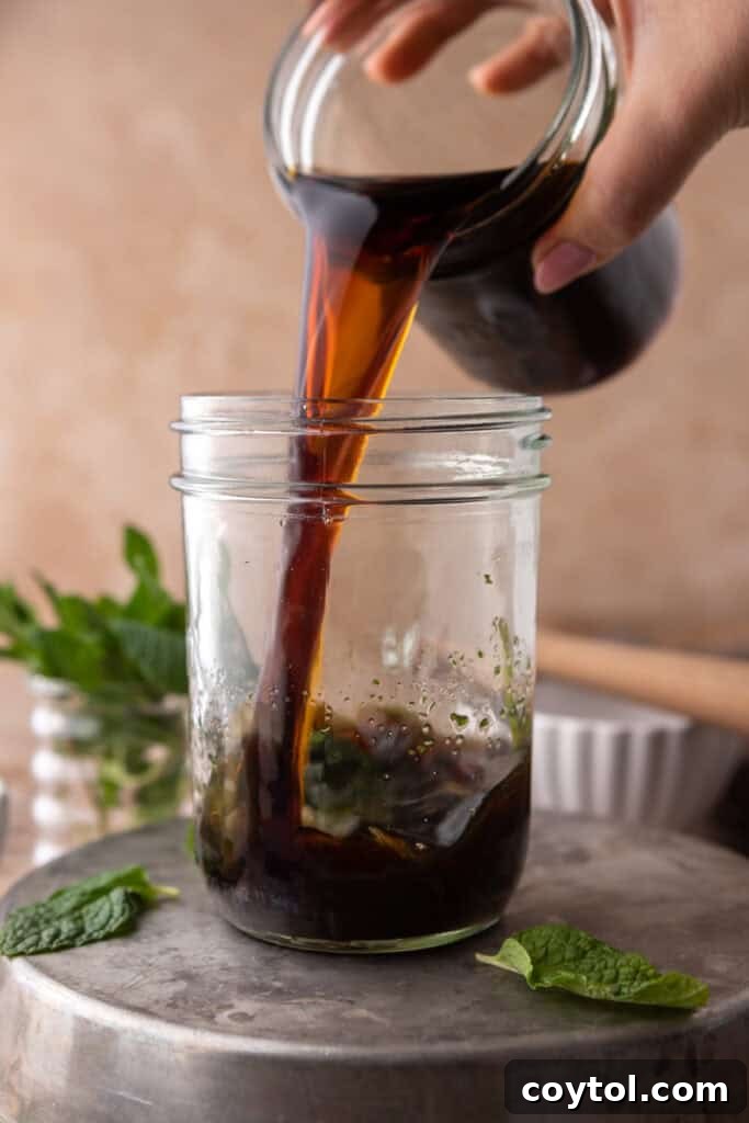 Hand pouring cold brew coffee in a cup