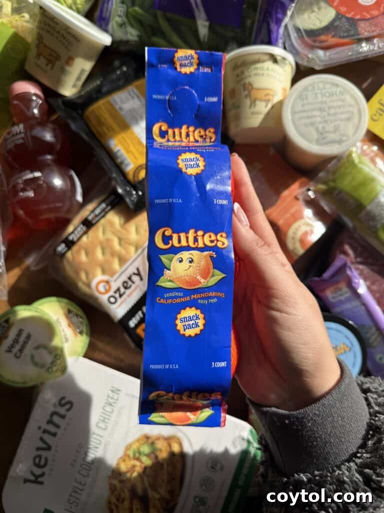A hand gently holding a collection of sweet and juicy cutie oranges, emphasizing fresh produce available.