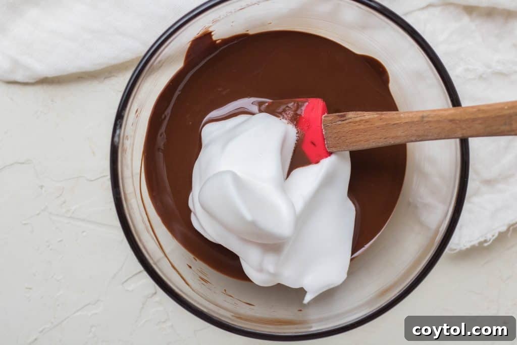 Close-up of melted dark chocolate with a spoon, showing its smooth and glossy texture.