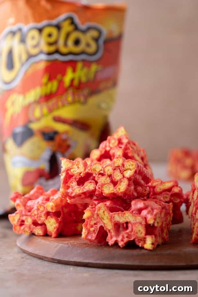 Several Hot Cheetos Marshmallow Crispy Treats stacked, showing the vibrant color and texture