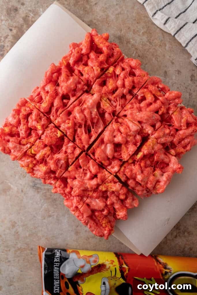 Finished Hot Cheetos Marshmallow Crispy Treats on a cutting board, ready to be sliced