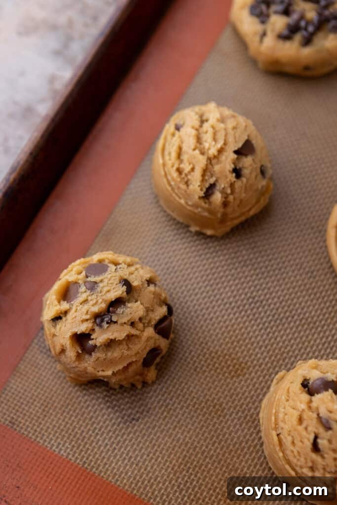 Balls of cookie dough on a baking sheet before baking