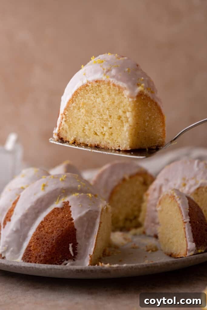Zesty & Moist Lemon Bundt Perfection 2 A beautifully sliced moist lemon bundt cake, showcasing its tender crumb and bright yellow color, held elegantly.