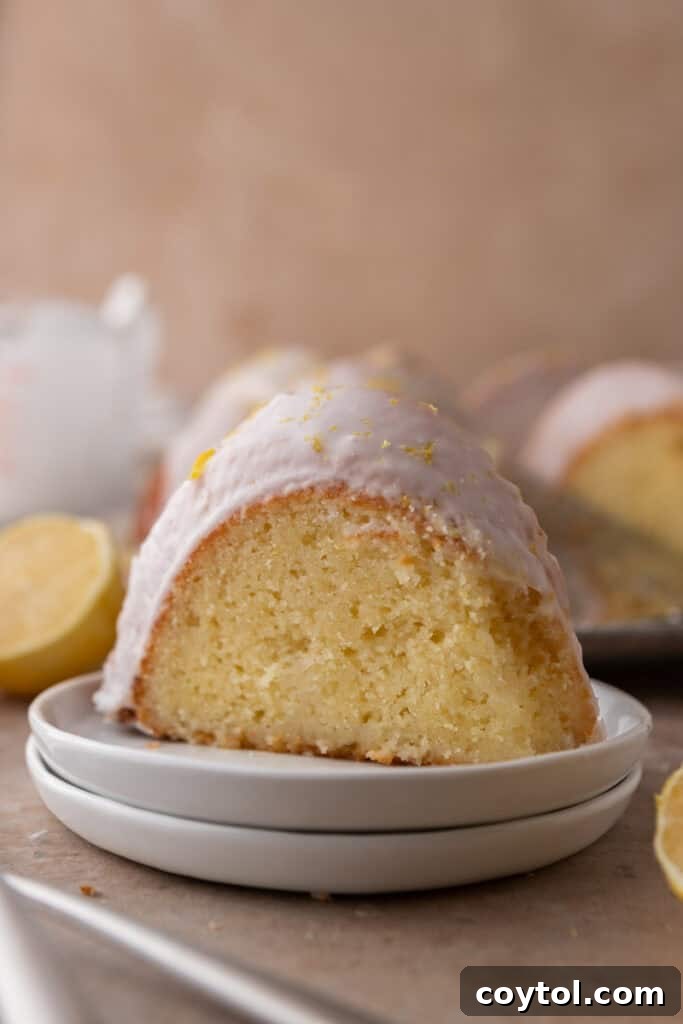 Zesty & Moist Lemon Bundt Perfection 17 A perfectly portioned slice of the lemon bundt cake on a white plate, ready to be enjoyed.