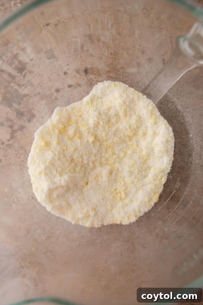 Zesty & Moist Lemon Bundt Perfection 6 Lemon zest being rubbed into granulated sugar