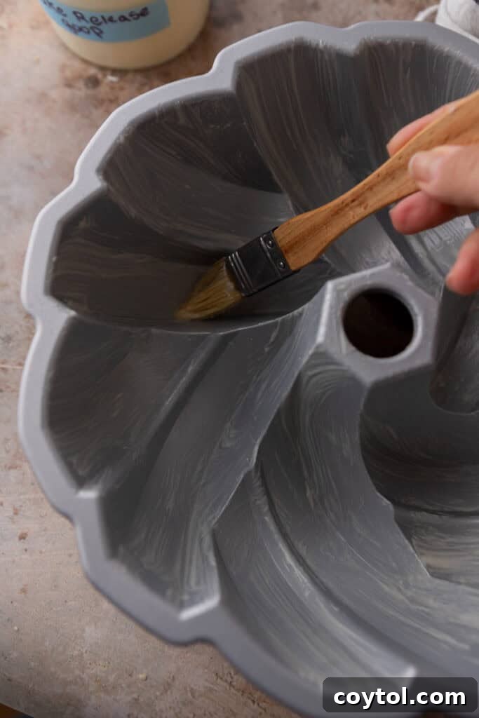 A pastry brush applying homemade cake release to a baking pan