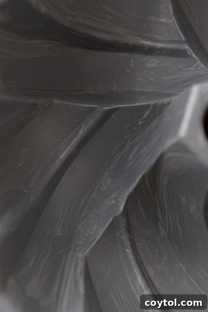 Close-up of a pastry brush applying homemade cake release to the intricate details of a pan