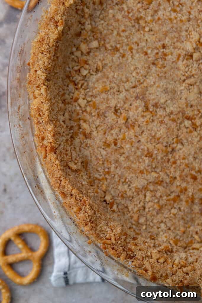 The Ultimate Salty Sweet Pretzel Pie Crust 13 Top-down view of a golden pretzel pie crust in a metal pie tin, ready for a filling.