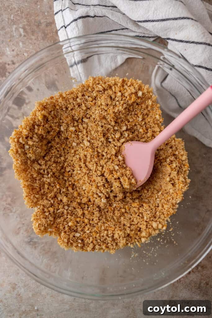 The Ultimate Salty Sweet Pretzel Pie Crust 7 Mixed pretzel crumbs, sugar, and butter in a bowl, showing the 'wet sand' consistency.
