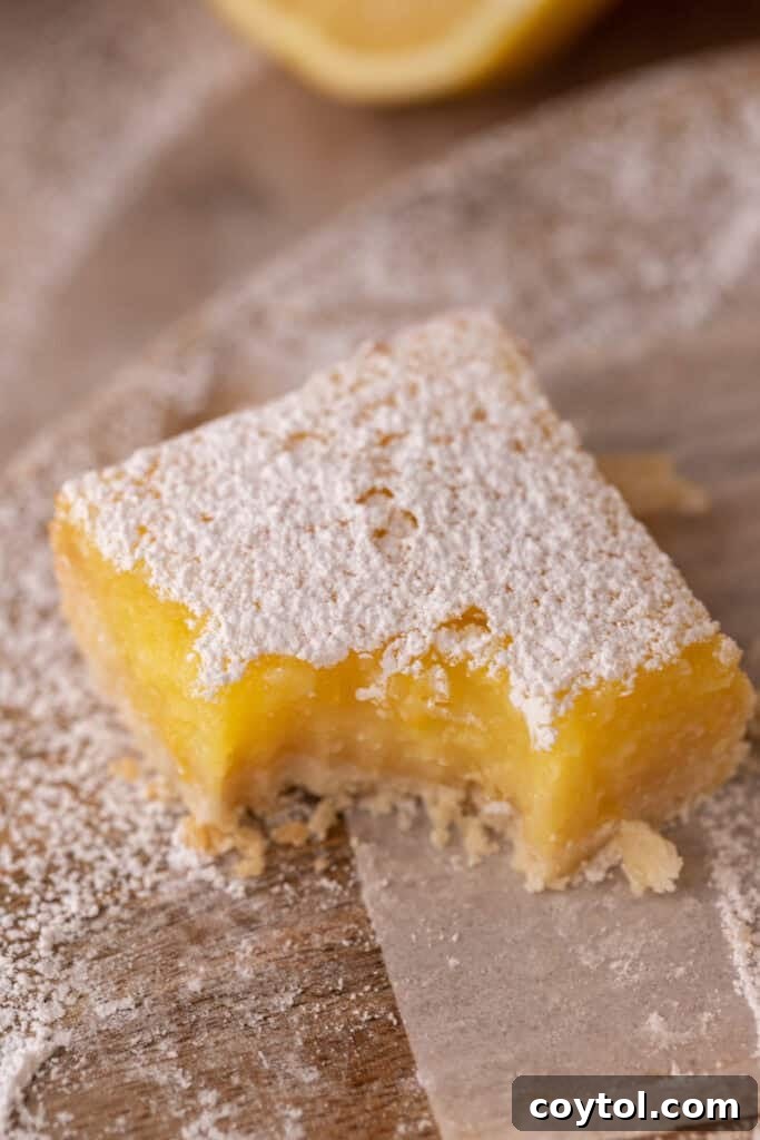 Small Batch Lemon Bars recipe with a bite taken out, showcasing the flaky crust and bright lemon filling.