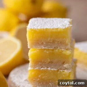 small batch lemon bars recipe stacked on top, showcasing the perfect golden crust and vibrant lemon curd.