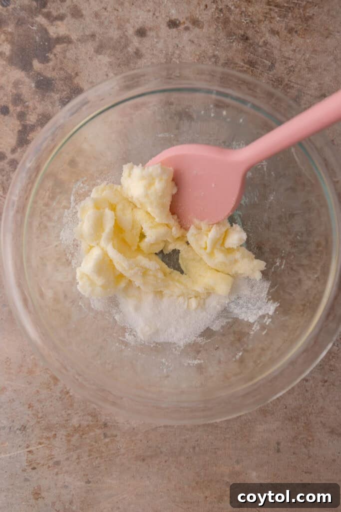 Unmixed ingredients for the shortbread crust in a bowl, showing butter, sugar, and flour.