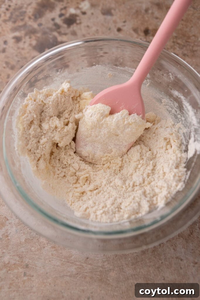 Close-up of softened butter and granulated sugar in a mixing bowl before creaming.