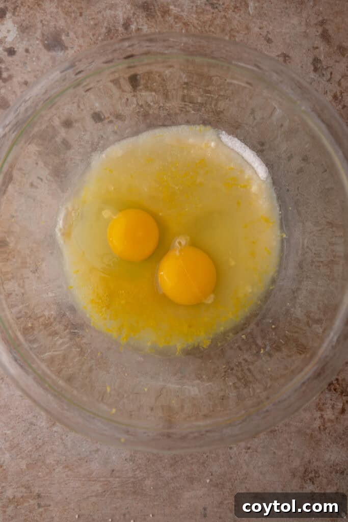 Unmixed ingredients for the lemon filling in a bowl, including eggs, sugar, and lemons.