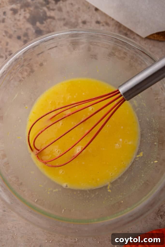 Mixed ingredients for the lemon filling, a smooth yellow mixture, in a bowl.
