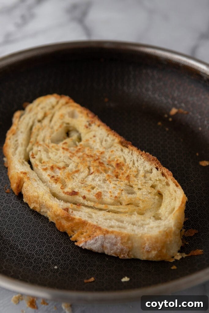 Slices of Croissant Sourdough Bread artfully arranged on a baking sheet, showcasing their beautiful golden crust and inviting texture.