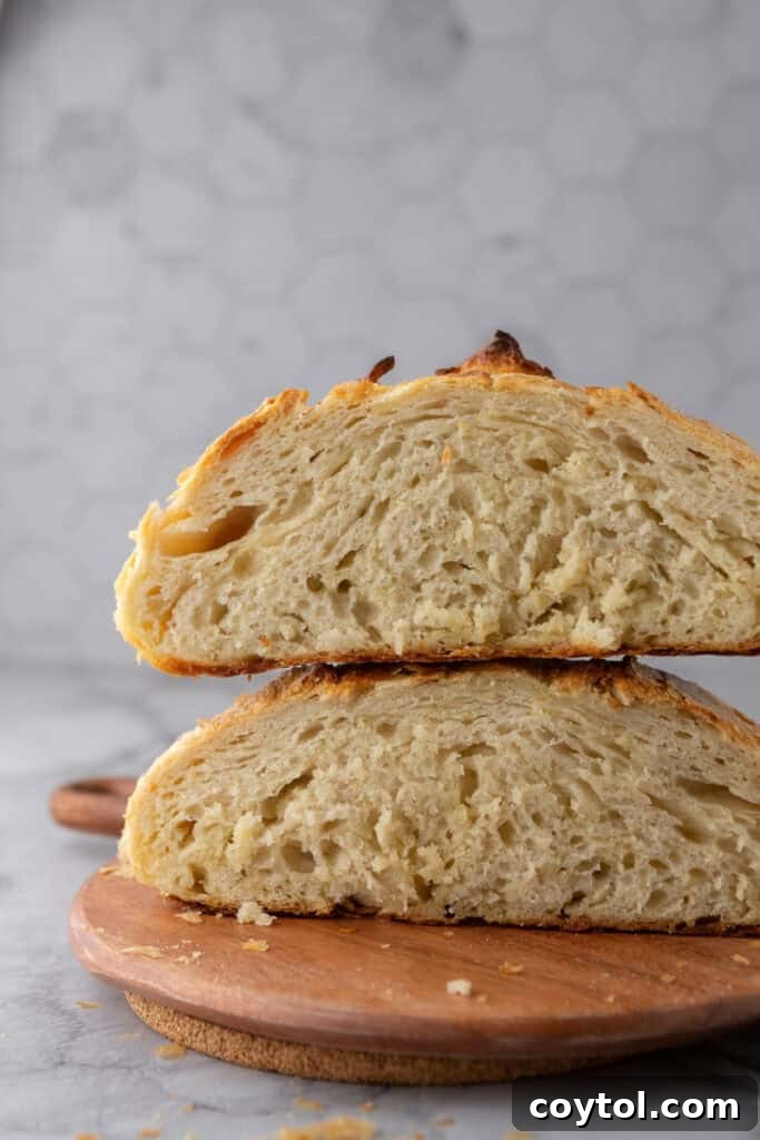 Two halves of a Sourdough Croissant Bread loaf stacked, revealing the beautiful, airy crumb and laminated layers within.