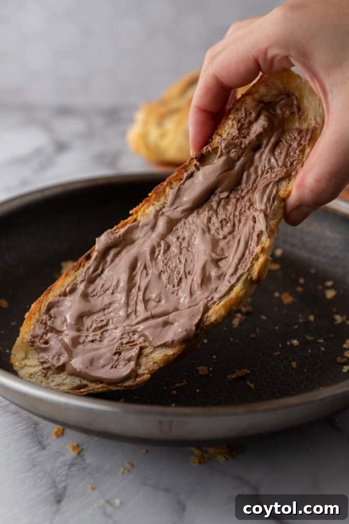 A crisp, golden-brown slice of Croissant Sourdough Bread being toasted, ready to be enjoyed.