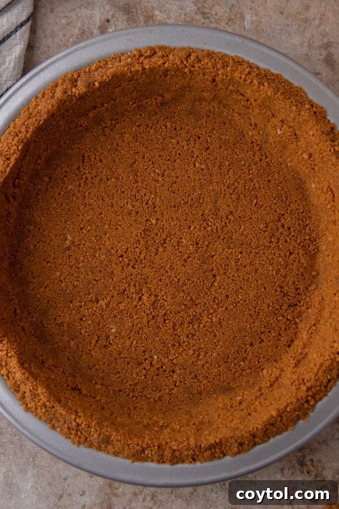 Unlock the Secret to the Perfect Biscoff Pie Crust 2 Overhead shot of a golden brown Biscoff pie crust in a pie plate, ready for filling.