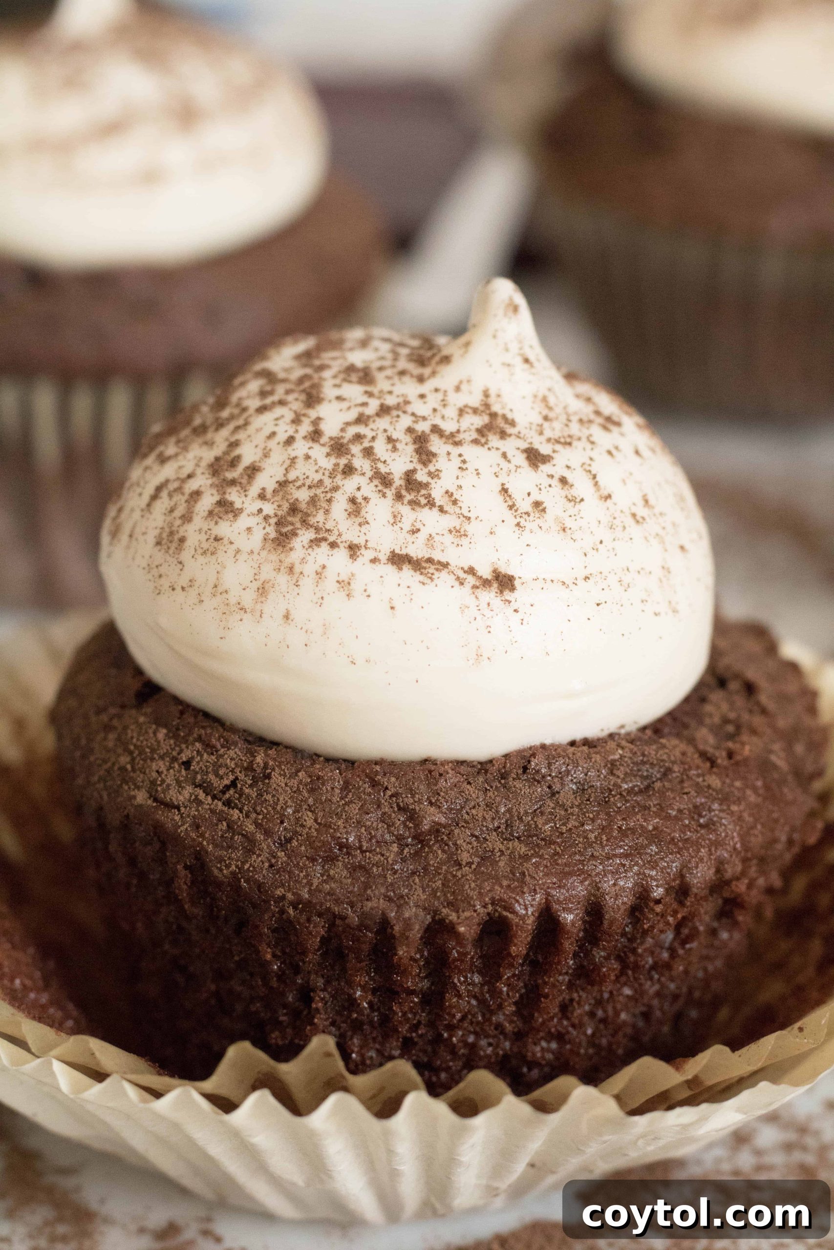 Cream cheese frosting piped on a chocolate cupcake