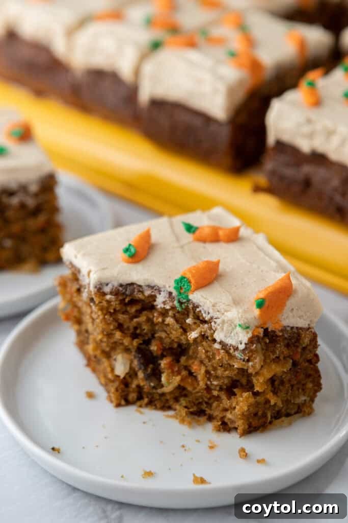 A beautiful slice of Carrot Cake Sheet Cake on a plate, showcasing its fluffy texture and rich frosting