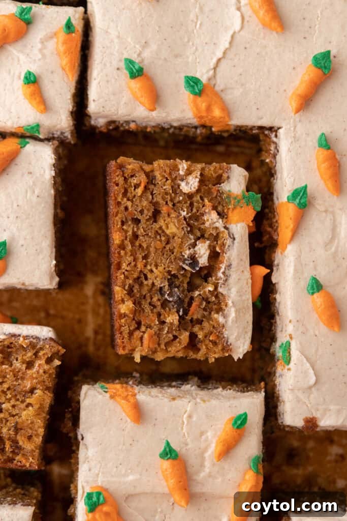 A perfectly sliced piece of Carrot Cake Sheet Cake, showing off its moist layers and creamy brown butter frosting