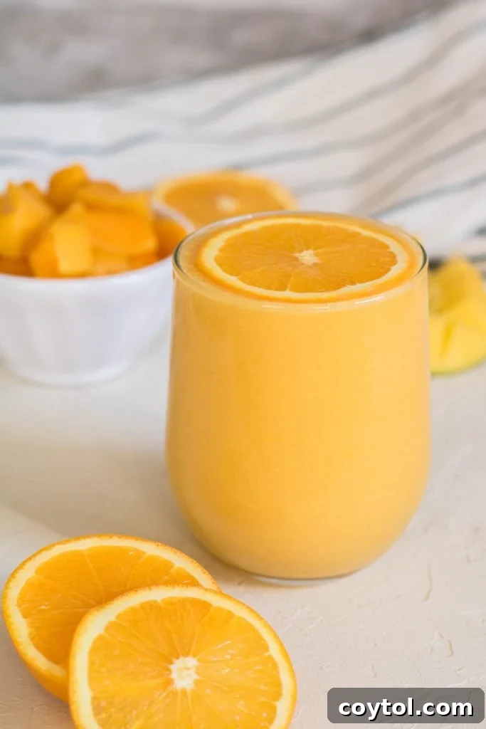Mango orange smoothie with an orange slice on top