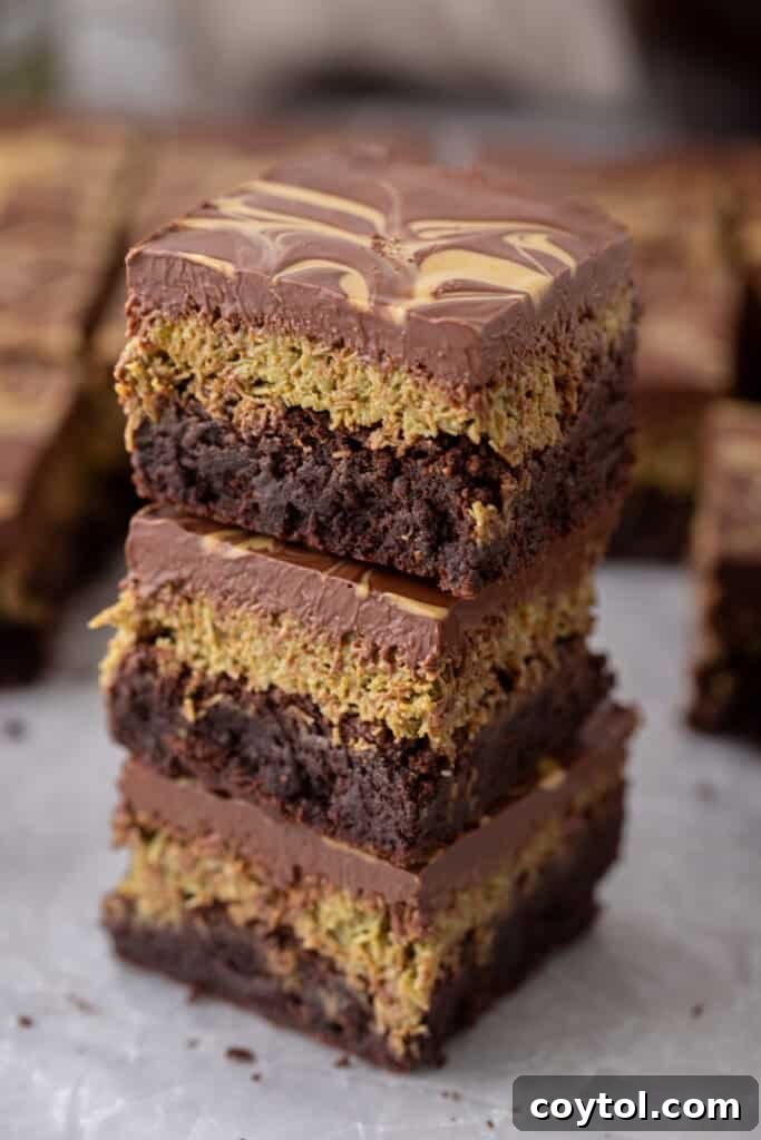 Stacked Dubai Chocolate Brownies Recipe showing layers of fudgy brownie, crispy kataifi, and glossy chocolate with pistachio swirls.