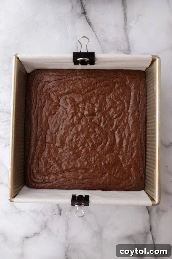 Freshly baked brownie in the pan, showing a crinkly top.