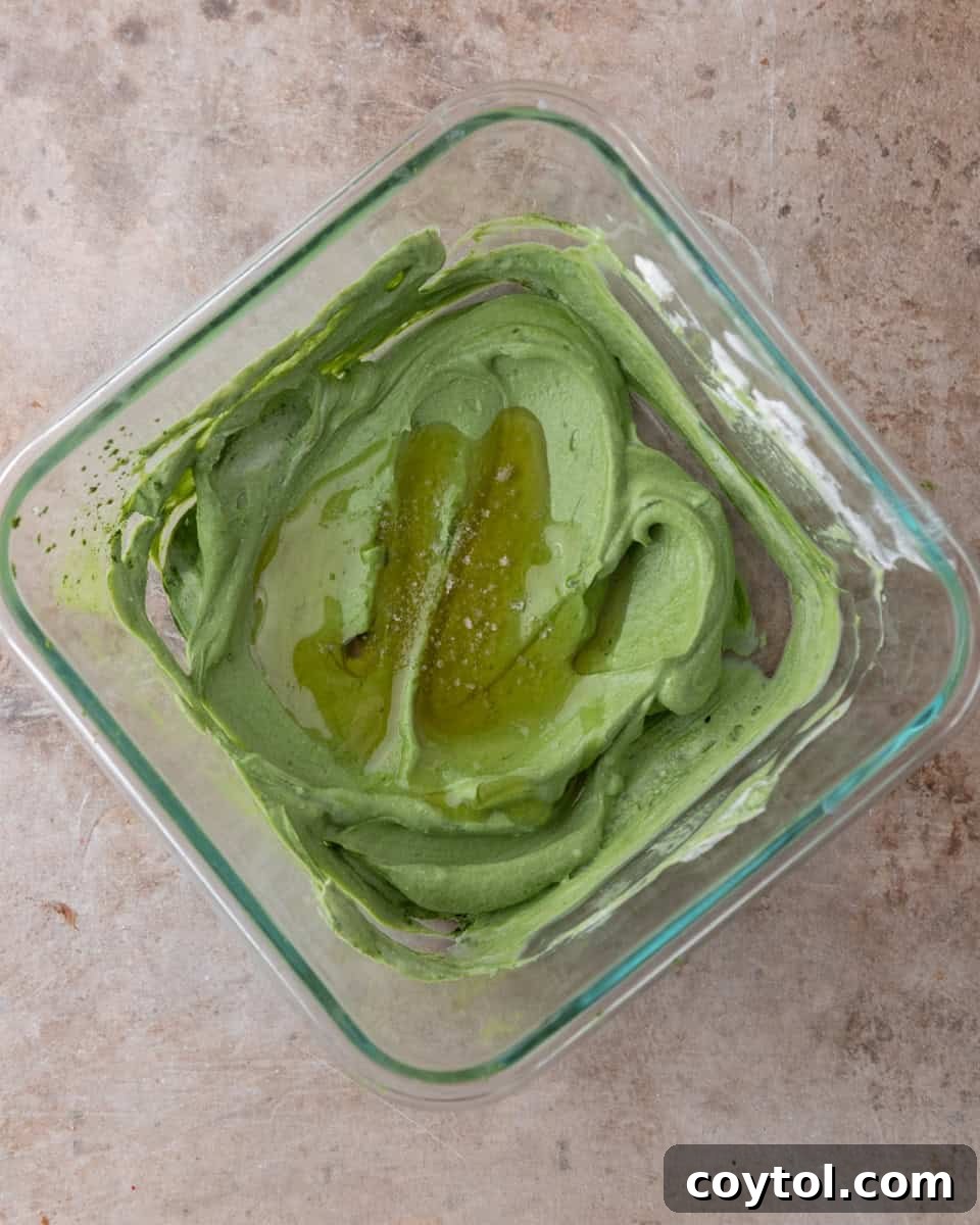 Smooth, vibrant green matcha yogurt mixture infused with maple syrup and salt, ready for the liquid and chia seeds.