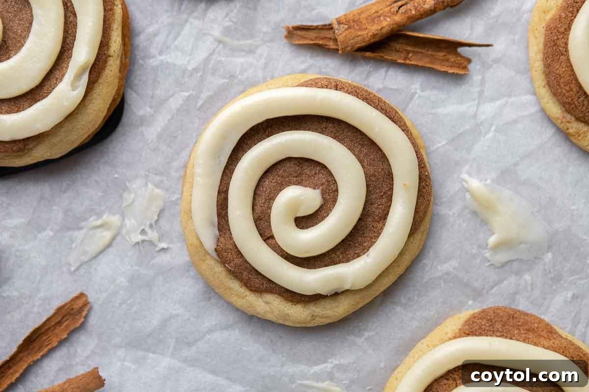 Crumbl cinnamon swirl cookie with cream cheese frosting spiral on parchment paper
