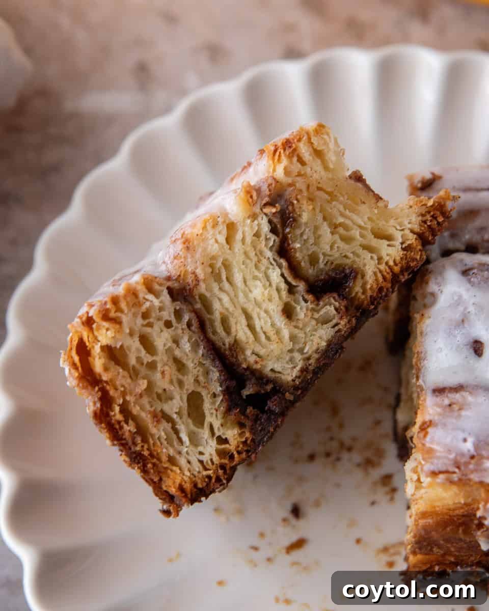 Croissant cinnamon roll cut in half showing flaky laminated layers