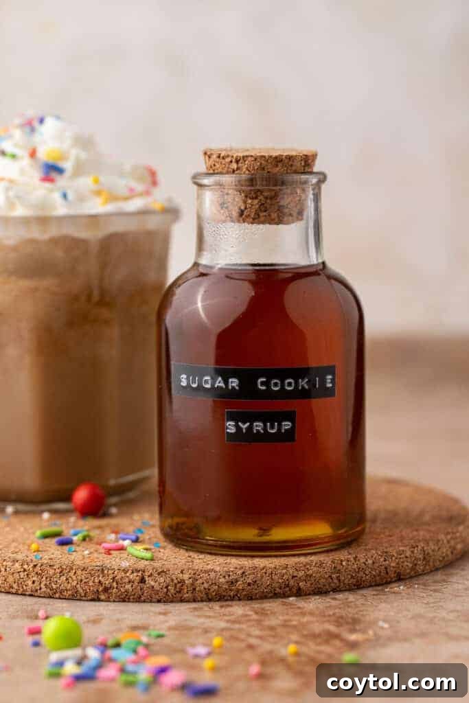 Unlock Starbucks Flavors: 65+ Beloved Recipes You Can Make 15 Homemade Starbucks sugar cookie syrup in a corked glass bottle with a holiday sugar cookie latte behind it