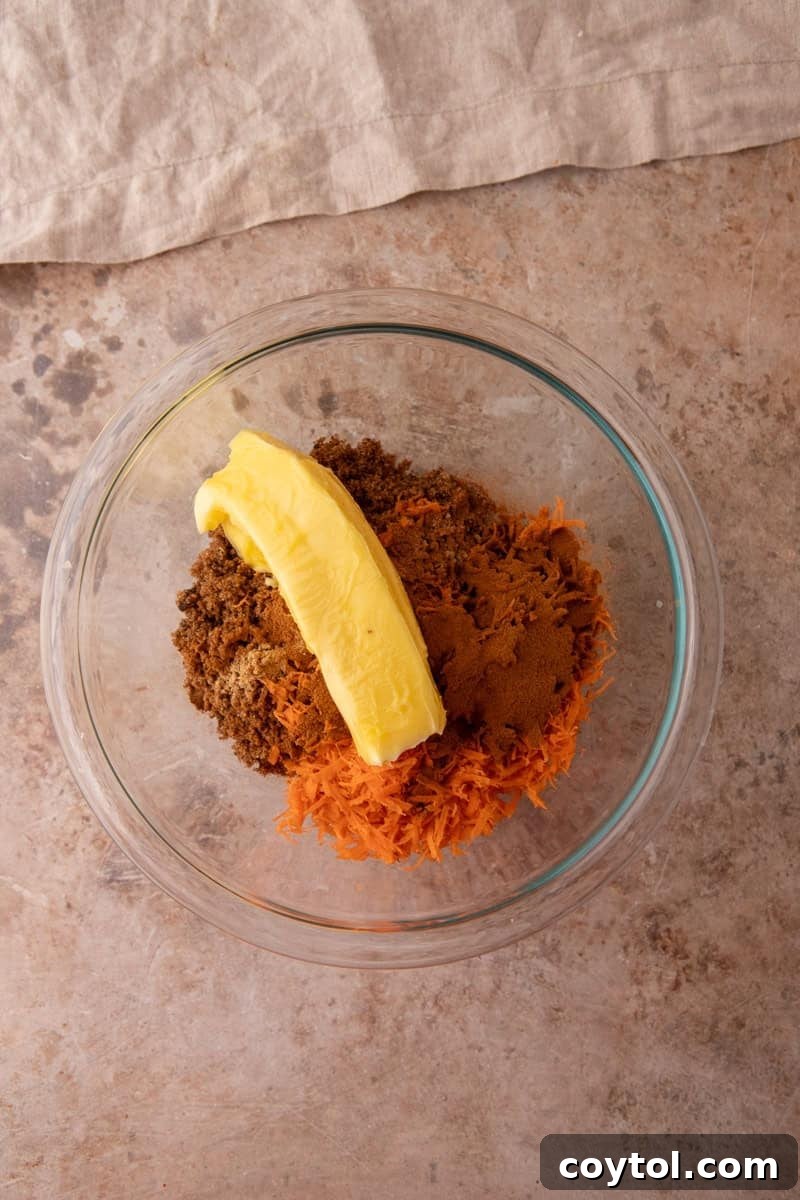 Softened butter, brown sugar, shredded carrots, and cinnamon in a glass bowl before mixing the carrot cake filling