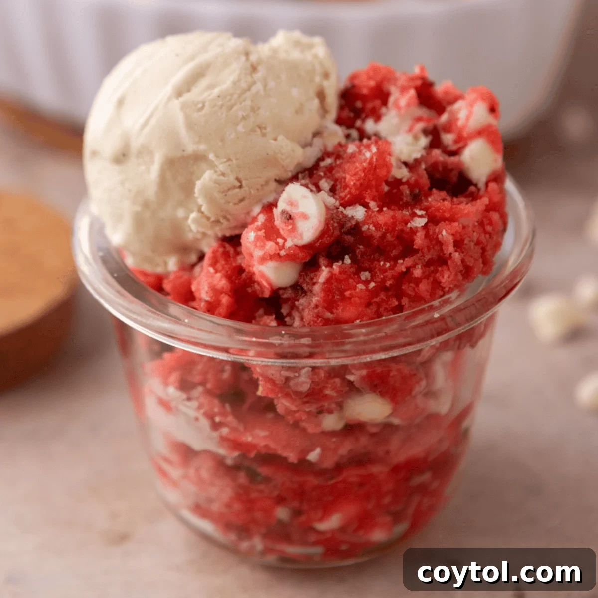 Strawberry scoopable cookie served in a glass jar with a scoop of vanilla ice cream on top