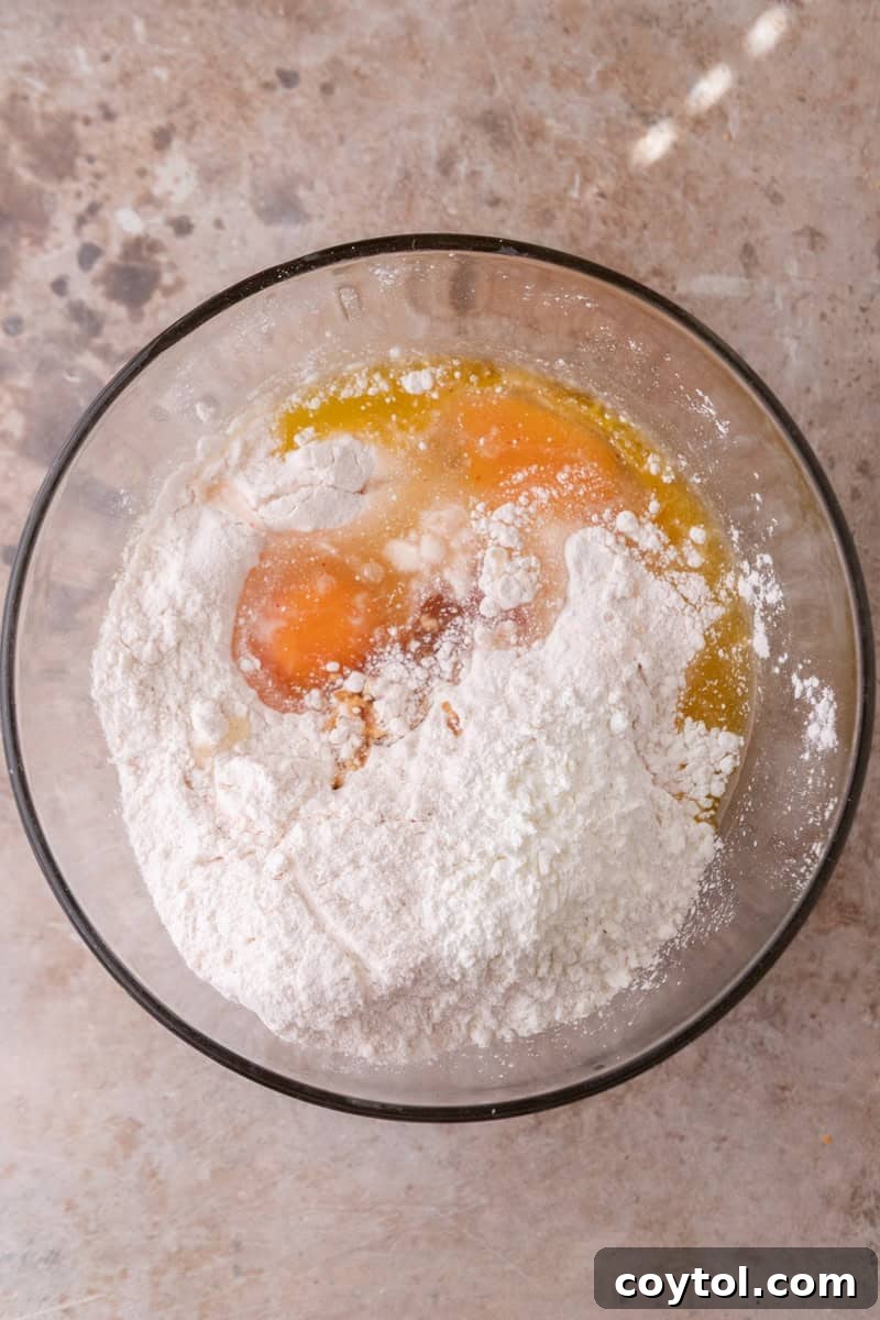 Strawberry cake mix, eggs, and melted butter combined in a glass mixing bowl before stirring