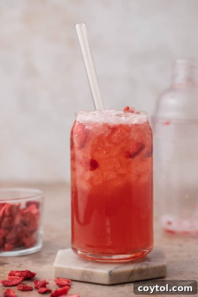 Effortless Easter Treats: Over 20 Recipes for a Memorable Spring Feast 9 Homemade Starbucks strawberry acai refresher in a glass can cup with a glass straw and freeze dried strawberries on the side