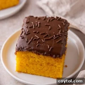 Vibrant Brazilian Carrot Cake with Decadent Chocolate Glaze 16 A single square of Brazilian carrot cake with chocolate frosting and sprinkles on a small white plate, ready to be enjoyed.