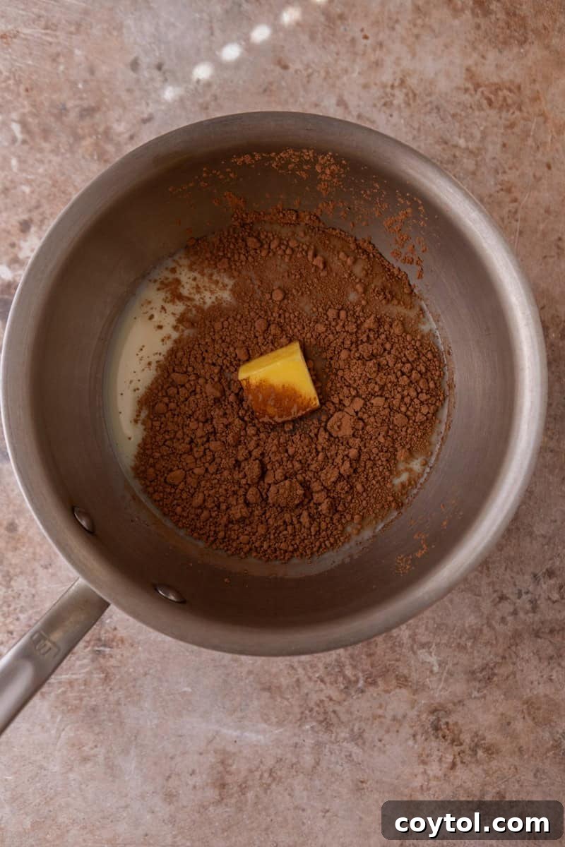 Vibrant Brazilian Carrot Cake with Decadent Chocolate Glaze 10 A saucepan on a stovetop, containing cocoa powder, a pat of butter, and an open can of sweetened condensed milk, poised for heating and stirring to create the chocolate glaze.