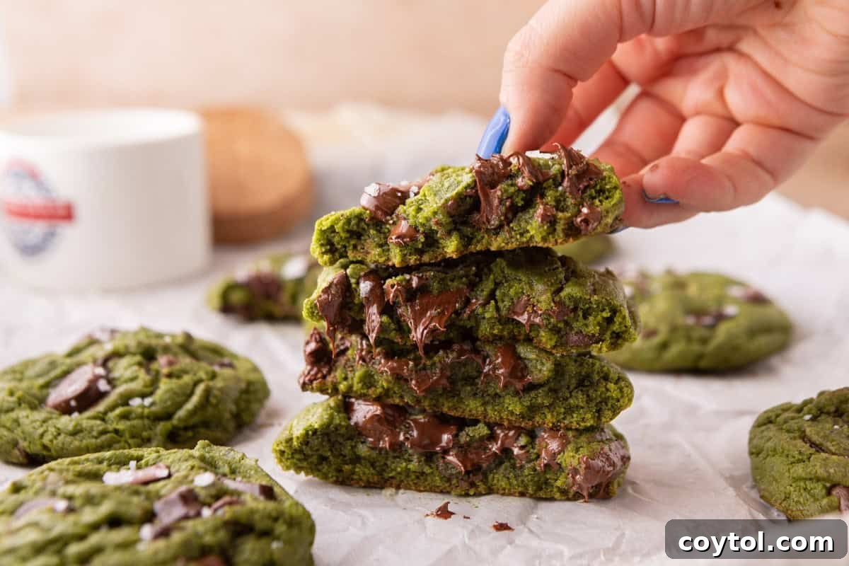 Stack of broken matcha chocolate chip cookies showing the soft chewy center and gooey melted chocolate