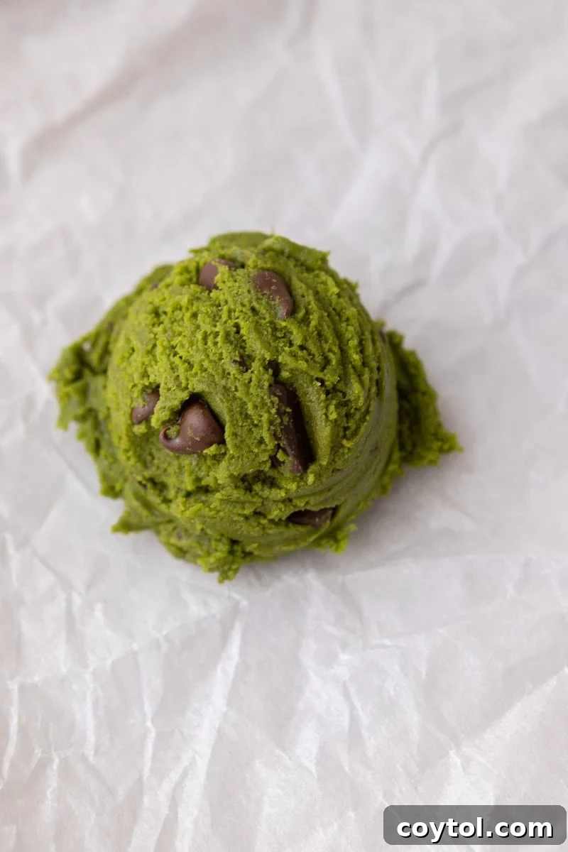 Finished matcha cookie dough with chocolate chips mixed throughout in a glass bowl