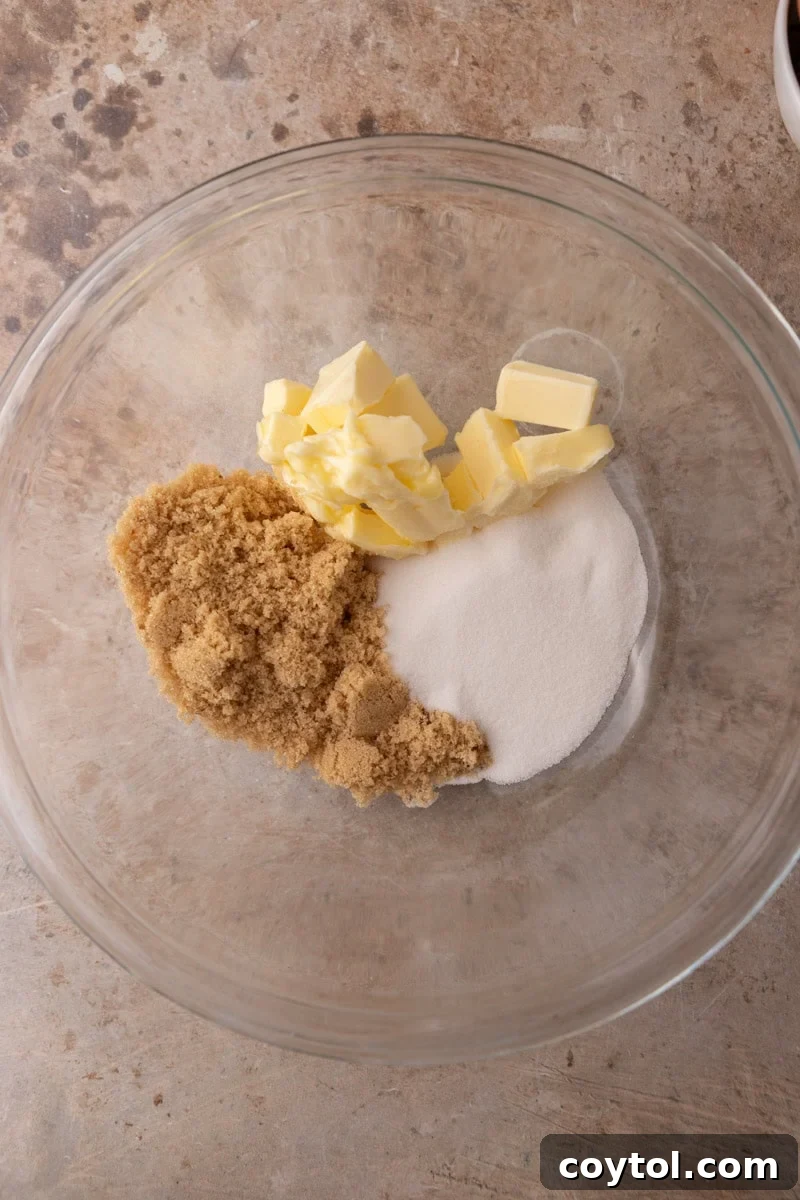Softened butter, brown sugar, and granulated sugar in a glass mixing bowl before creaming

