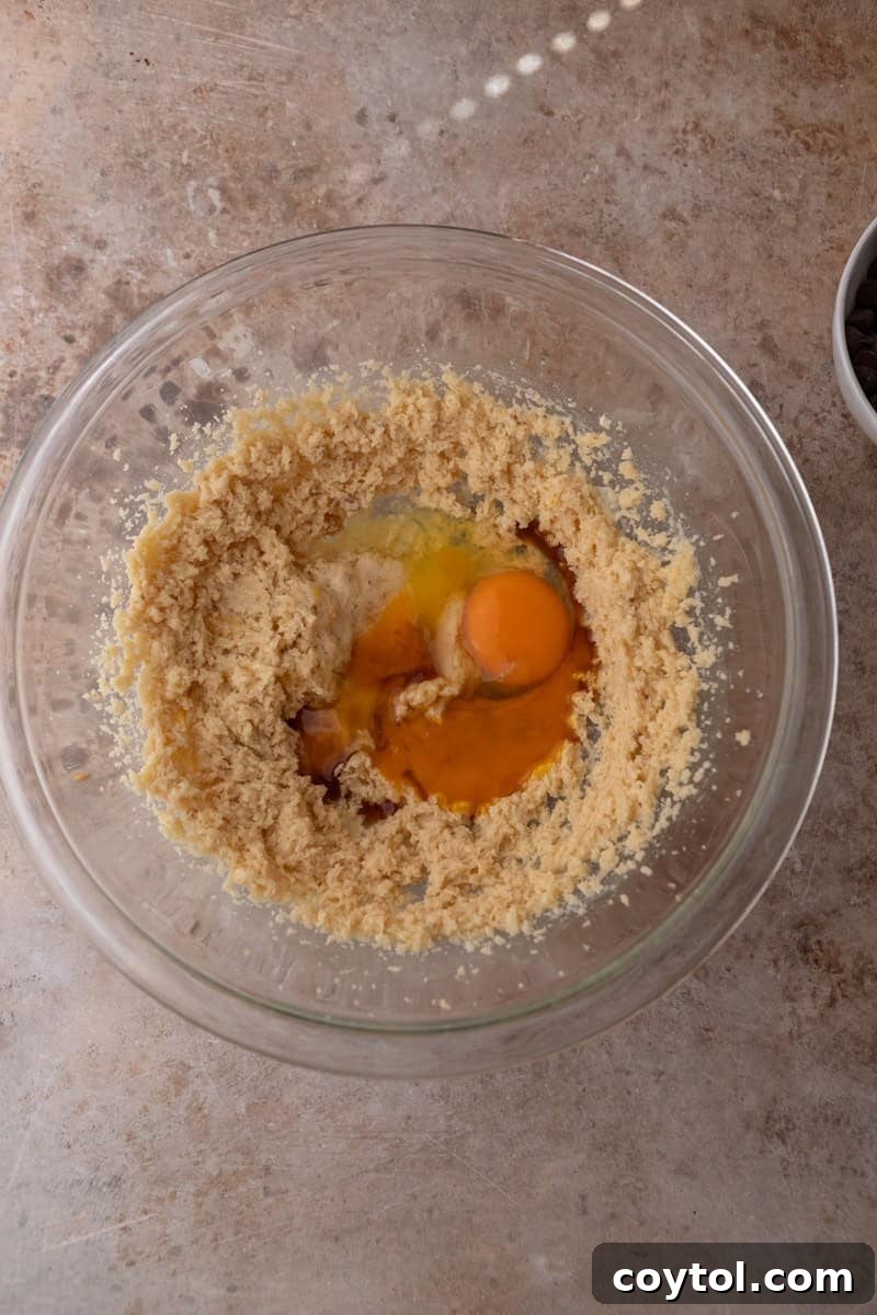 Creamed butter and sugar mixture with an egg and egg yolk added to the bowl
