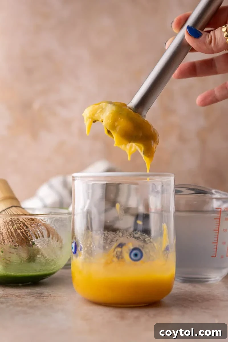 Fresh Mango Matcha Coconut Water Delight 5 immersion blender smoothly pureeing fresh mango directly in the serving glass