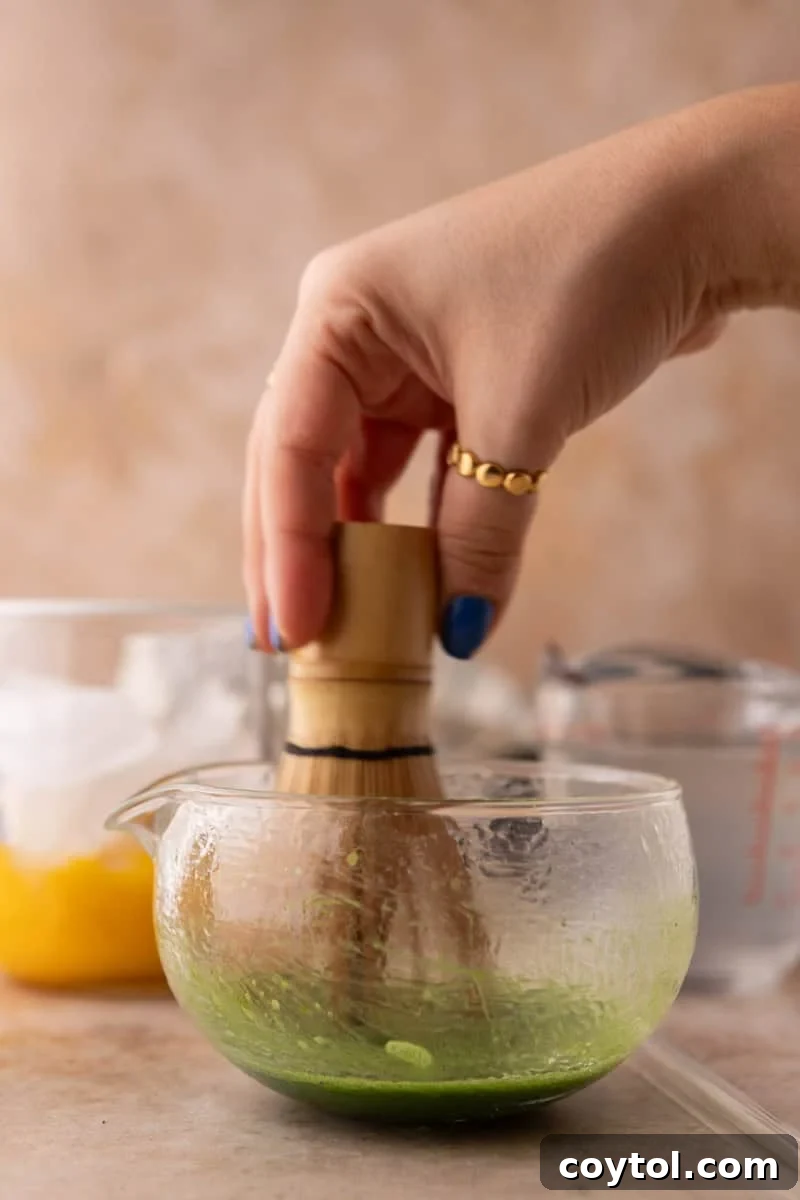 Fresh Mango Matcha Coconut Water Delight 7 whisking ceremonial grade matcha powder with hot water using a traditional bamboo whisk