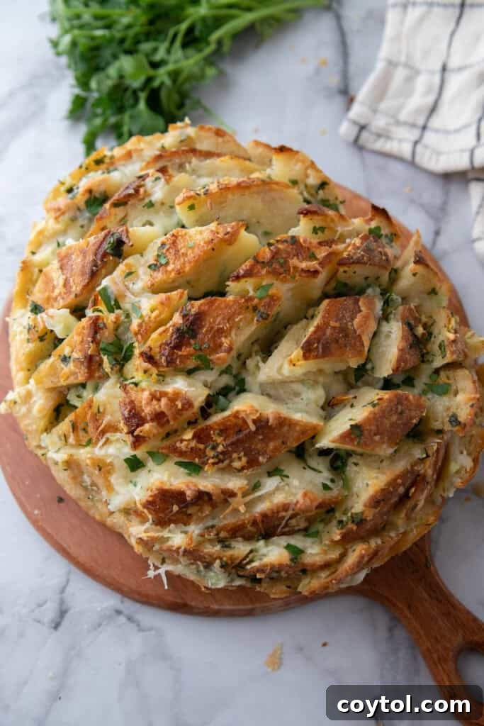 Golden Gooey Garlic Bread Pull Apart Perfection 12 Golden baked garlic cheese bread served beautifully on a rustic wooden board, ready for sharing and a communal culinary experience.