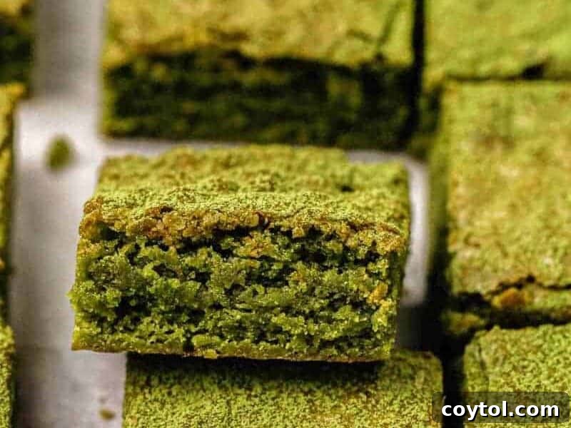 Close up shot showing the vibrant green interior texture of perfectly baked matcha brownies, highlighting their unique color and rich green tea flavor, transporting you to Japan.