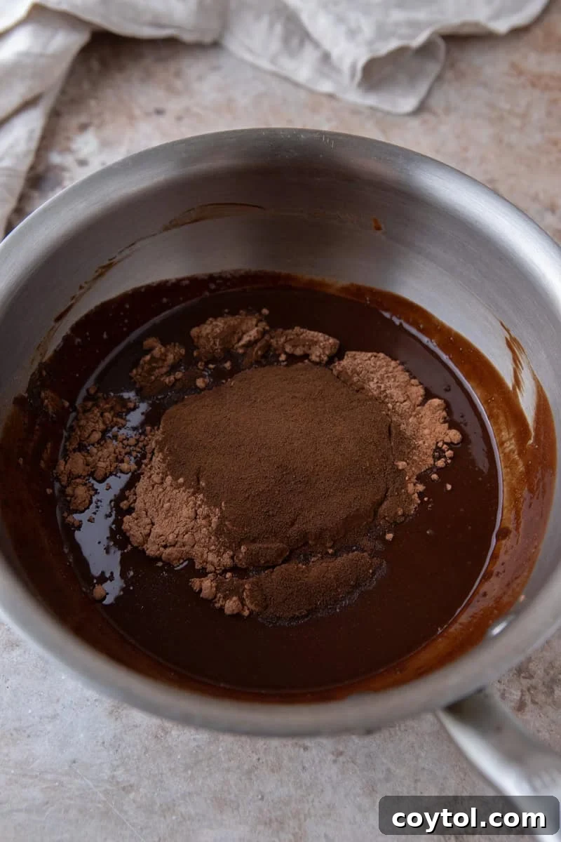 Melted chocolate mixture with cocoa powder and espresso powder added in a saucepan